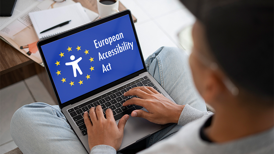 Person viewing a laptop screen displaying the European Accessibility Act logo.